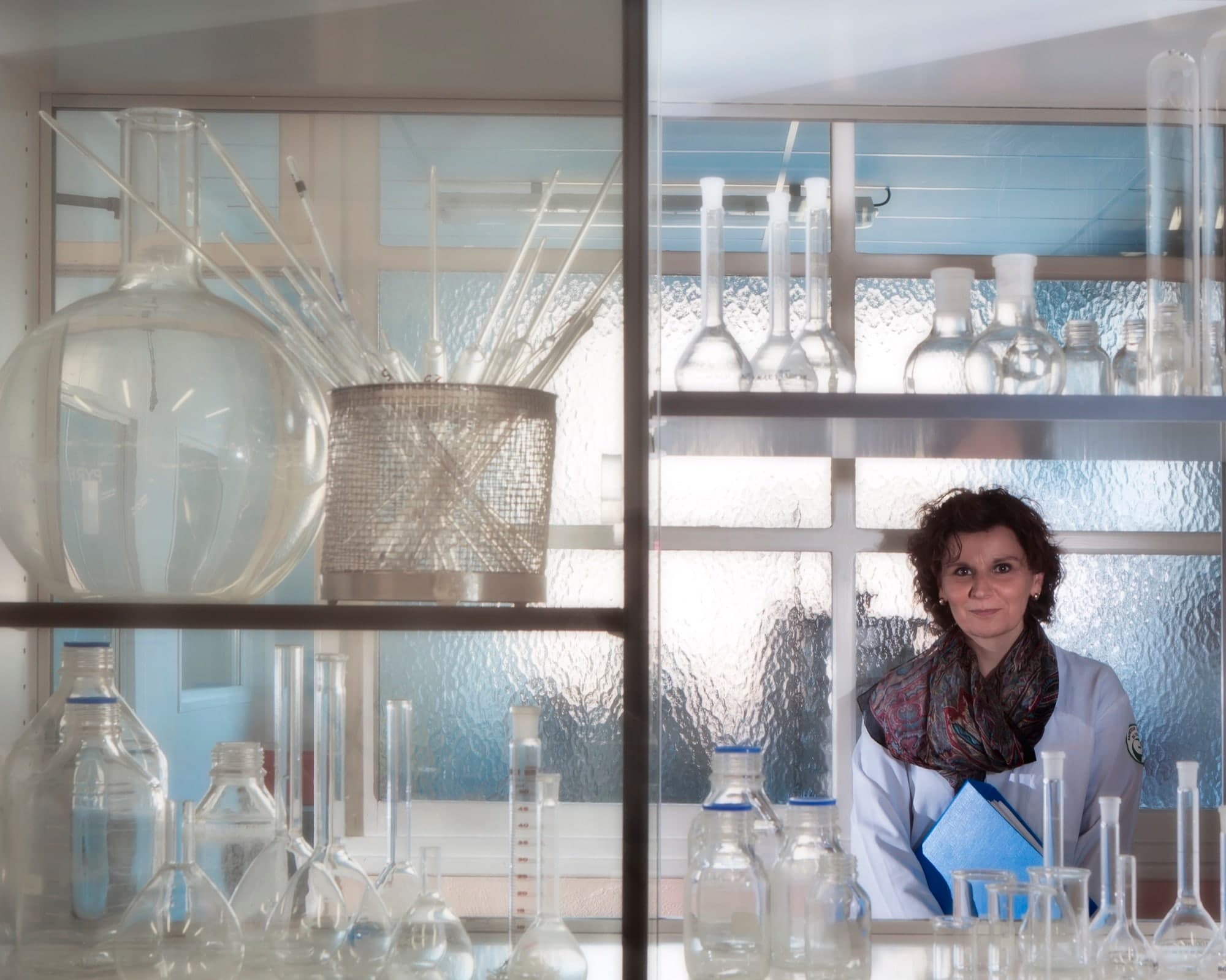 Portrait d'une femme en blouse blanche dans un laboratoire de verrerie