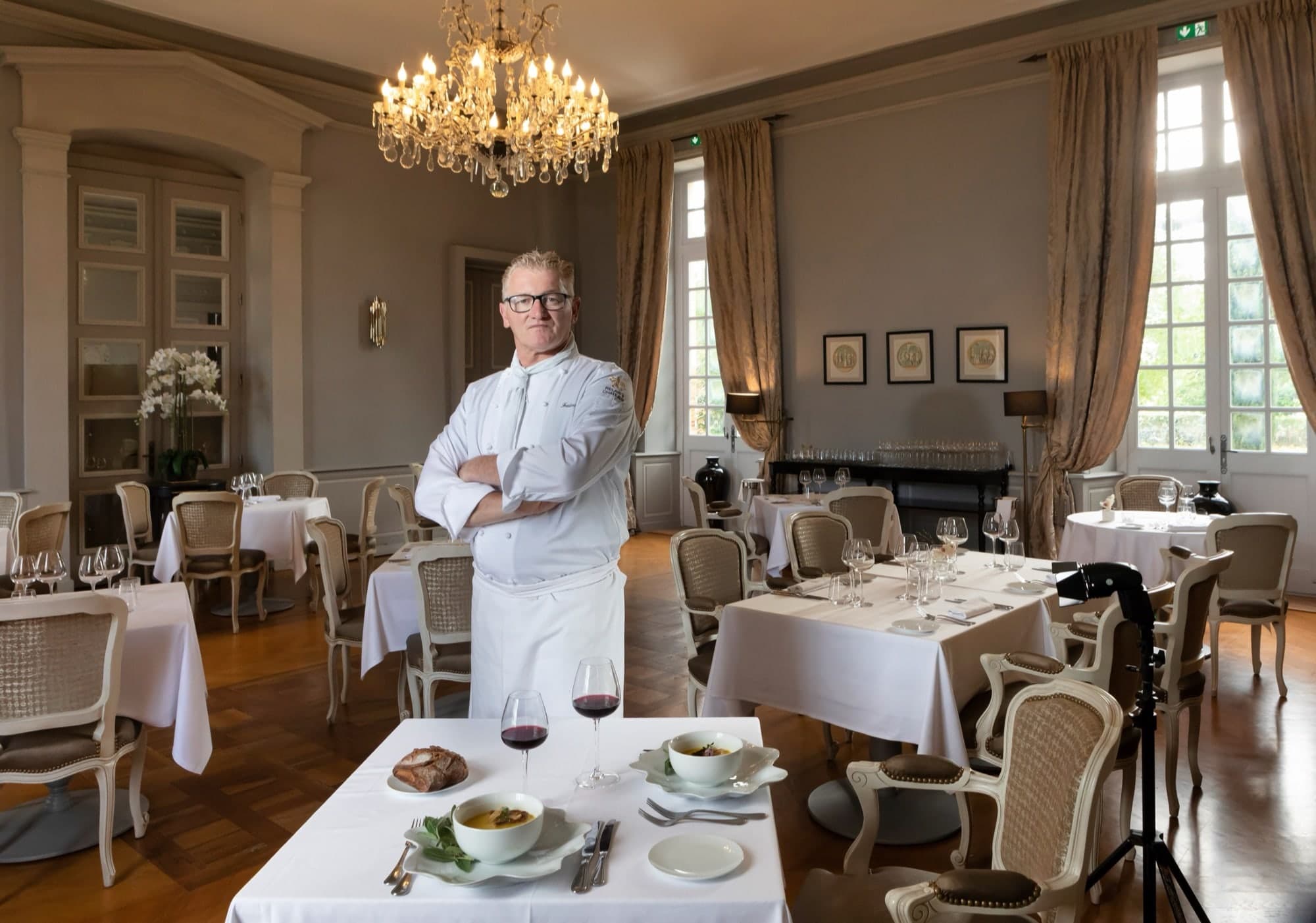 Chef cuisinier posant dans la salle du restaurant