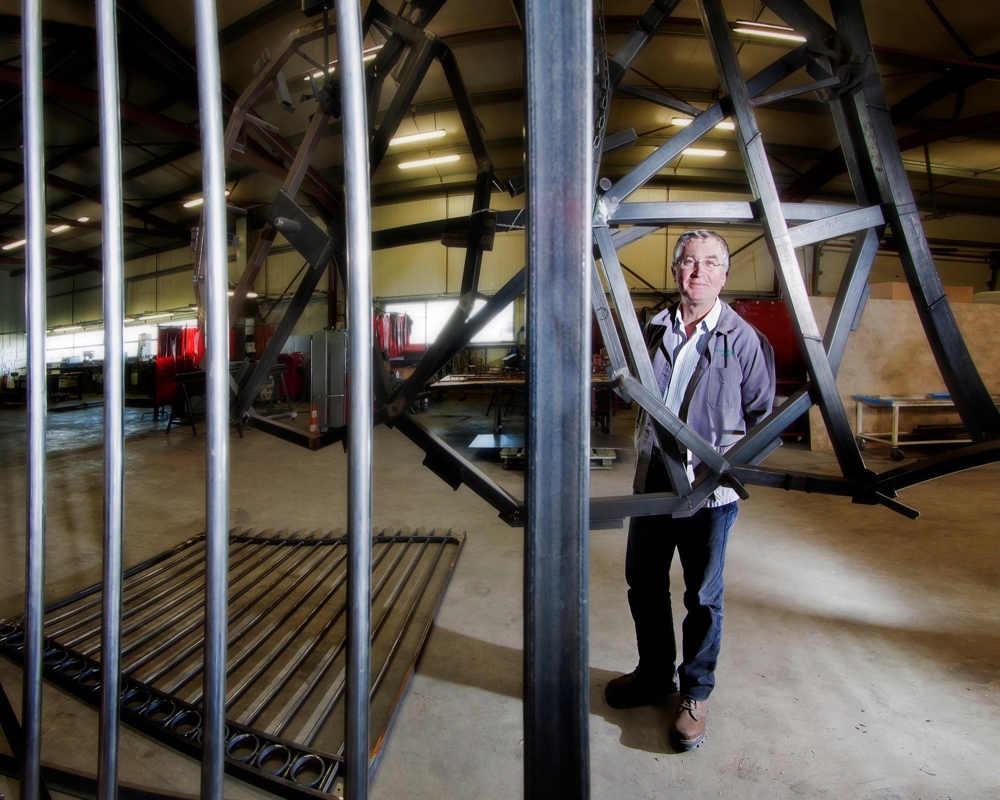 Portrait d'un homme debout devant une imposante structure métallique industrielle
